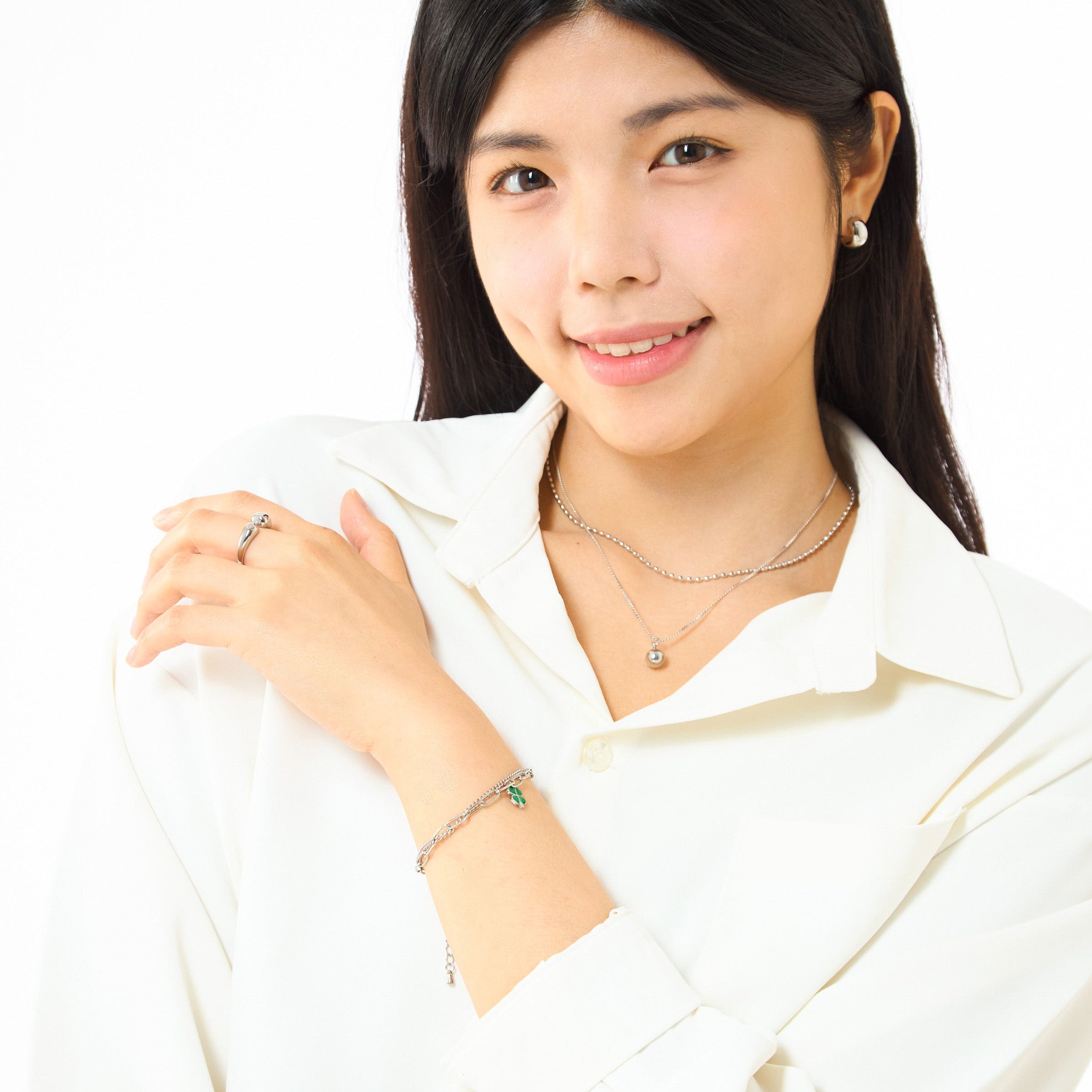 Woman wearing a white blouse with jewelry on a white background